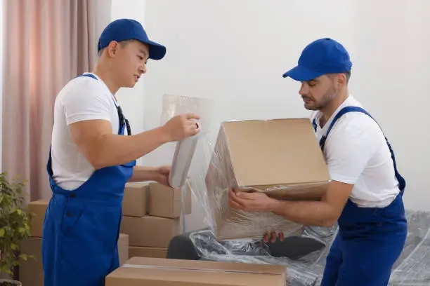 movers carefully wrapping and boxing items